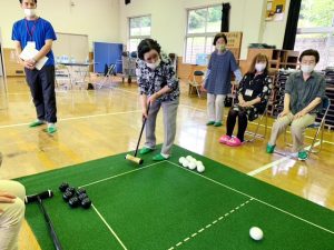 体育館でパターゴルフを楽しむ利用者さん