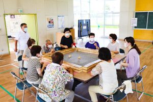 体育館でテーブルを囲み麻雀を楽しむ利用者さん